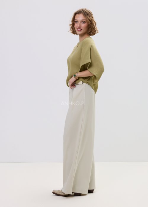 Bluzka damska oversize oliwkowa z szerokim rękawem kimono, lekka i zwiewna, stylizowana z jasnymi spodniami o wysokim stanie.