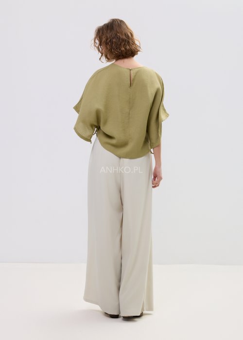 Bluzka damska oversize oliwkowa z szerokim rękawem kimono, lekka i zwiewna, stylizowana z jasnymi spodniami o wysokim stanie.