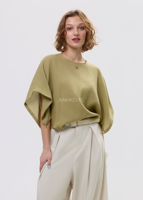 Bluzka damska oversize oliwkowa z szerokim rękawem kimono, lekka i zwiewna, stylizowana z jasnymi spodniami o wysokim stanie.