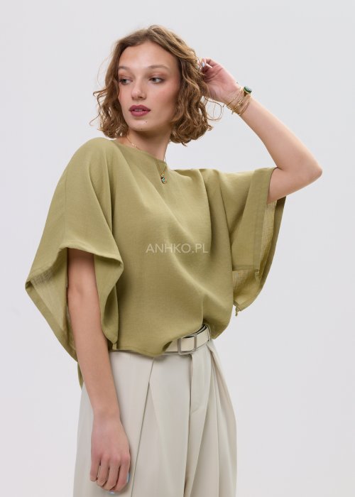 Bluzka damska oversize oliwkowa z szerokim rękawem kimono, lekka i zwiewna, stylizowana z jasnymi spodniami o wysokim stanie.