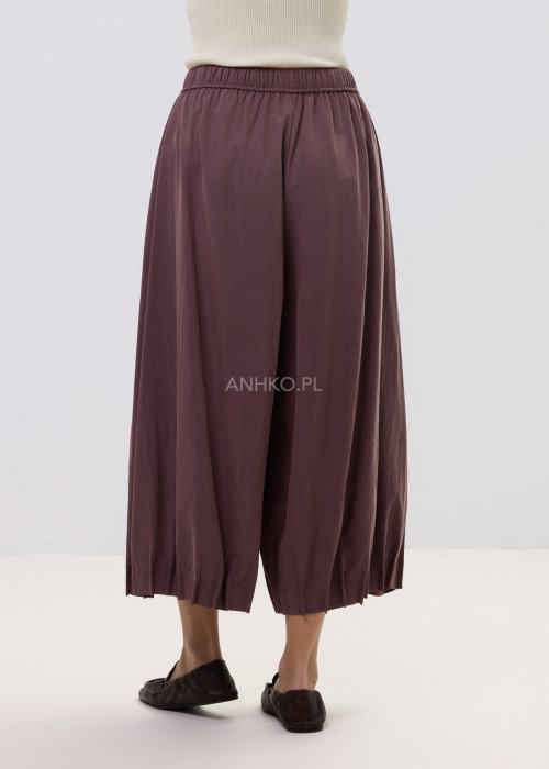 Spodnie damskie typu culotte w kolorze wina z szeroką nogawką i gumką w pasie, luźny fason z marszczeniem i wiązaniem w casualowej stylizacji.