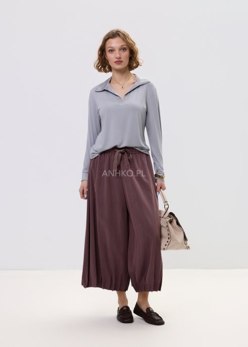 Spodnie damskie typu culotte w kolorze wina z szeroką nogawką i gumką w pasie, luźny fason z marszczeniem i wiązaniem w casualowej stylizacji.