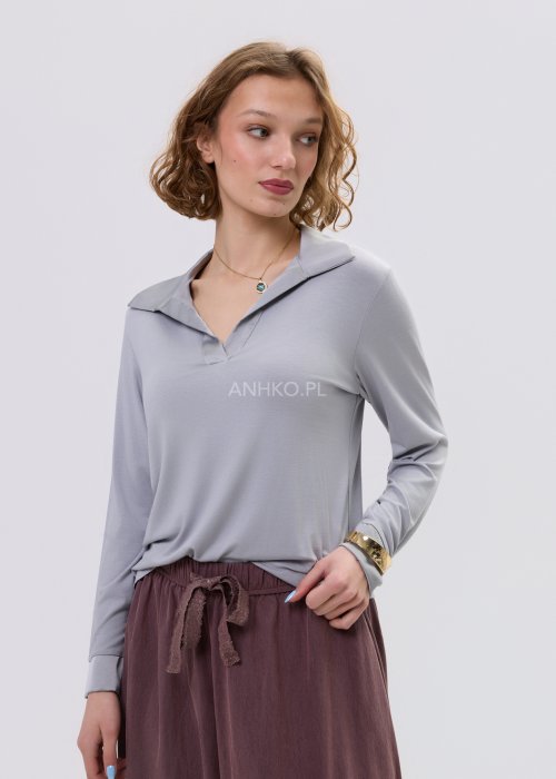 Szara bluzka damska z długim rękawem i dekoltem, o dopasowanym kroju, zestawiona z luźnymi spodniami w odcieniu brązu w stylu casual.
