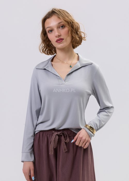 Szara bluzka damska z długim rękawem i dekoltem, o dopasowanym kroju, zestawiona z luźnymi spodniami w odcieniu brązu w stylu casual.