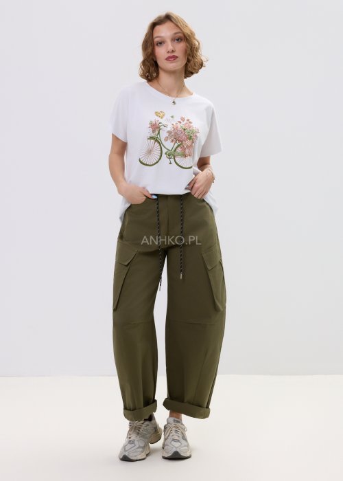 Biały T-shirt damski oversize z nadrukiem roweru i kwiatów, luźny fason w stylizacji z oliwkowymi spodniami.