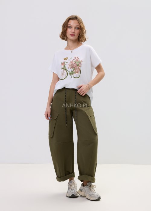 Biały T-shirt damski oversize z nadrukiem roweru i kwiatów, luźny fason w stylizacji z oliwkowymi spodniami.
