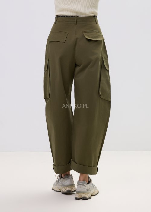 Spodnie damskie cargo khaki z wysokim stanem, szeroką nogawką i dużymi kieszeniami bocznymi, wykończone paskiem ze sznurkiem, stylizowane ze sneakersami.