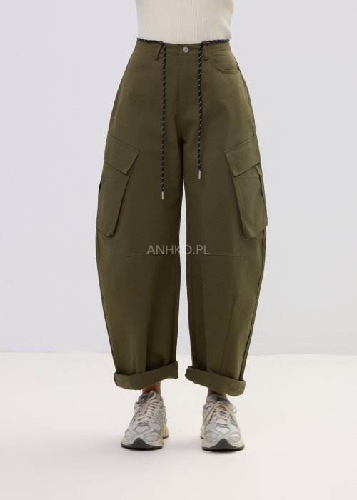 Spodnie damskie cargo khaki z wysokim stanem, szeroką nogawką i dużymi kieszeniami bocznymi, wykończone paskiem ze sznurkiem, stylizowane ze sneakersami.