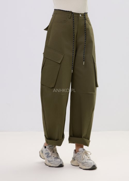 Spodnie damskie cargo khaki z wysokim stanem, szeroką nogawką i dużymi kieszeniami bocznymi, wykończone paskiem ze sznurkiem, stylizowane ze sneakersami.