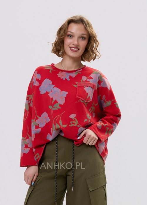 Czerwona bluza damska w kwiaty o luźnym kroju z długim rękawem i kieszonką na piersi, zestawiona z oliwkowymi spodniami w stylu casual.