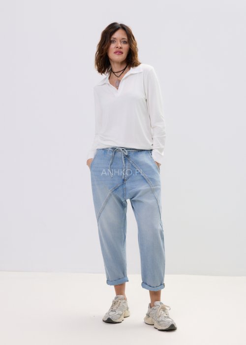 Spodnie damskie jeansowe jasnoniebieskie z obniżonym krokiem i przeszyciami, casualowy fason z podwiniętą nogawką i sportowym stylem.
