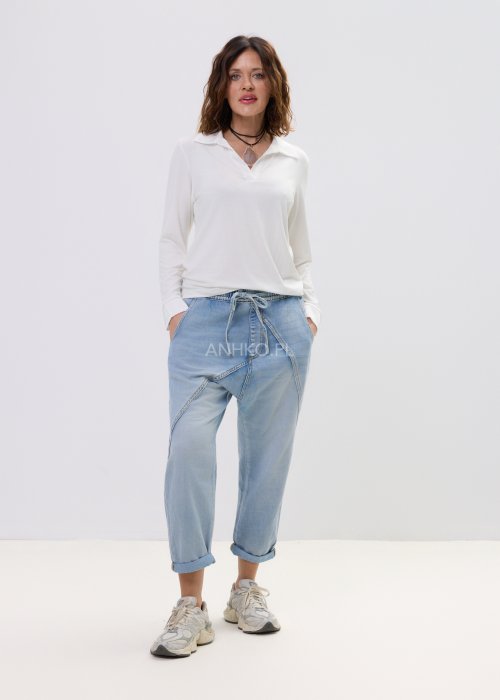 Spodnie damskie jeansowe jasnoniebieskie z obniżonym krokiem i przeszyciami, casualowy fason z podwiniętą nogawką i sportowym stylem.