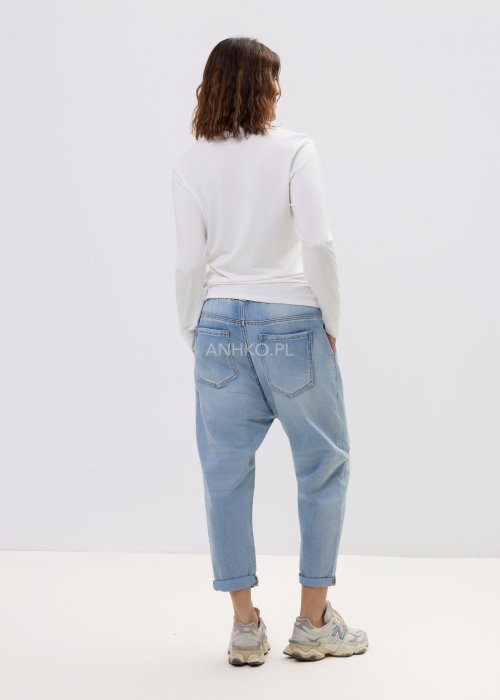 Spodnie damskie jeansowe jasnoniebieskie z obniżonym krokiem i przeszyciami, casualowy fason z podwiniętą nogawką i sportowym stylem.