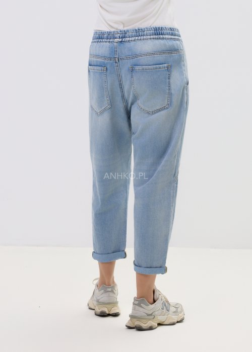 Spodnie damskie jeansowe jasnoniebieskie z obniżonym krokiem i przeszyciami, casualowy fason z podwiniętą nogawką i sportowym stylem.