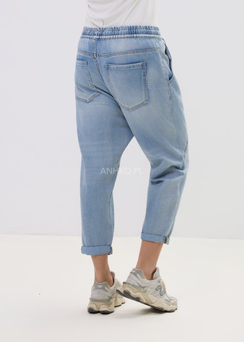 Spodnie damskie jeansowe jasnoniebieskie z obniżonym krokiem i przeszyciami, casualowy fason z podwiniętą nogawką i sportowym stylem.