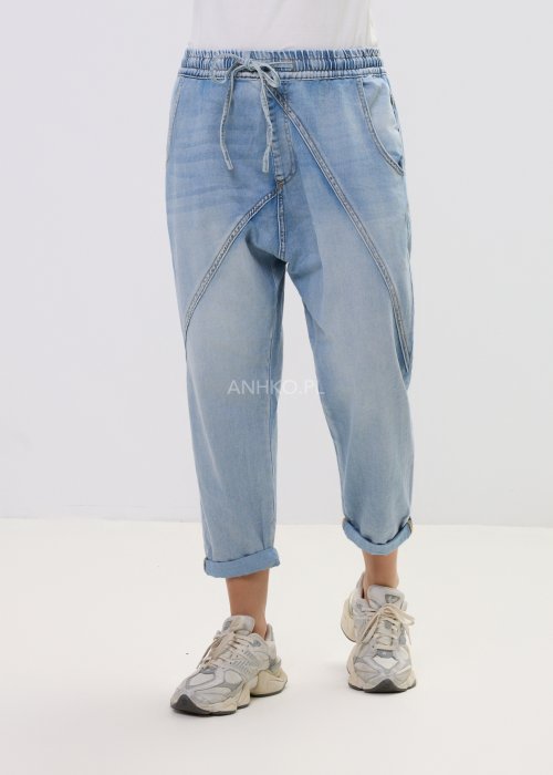 Spodnie damskie jeansowe jasnoniebieskie z obniżonym krokiem i przeszyciami, casualowy fason z podwiniętą nogawką i sportowym stylem.