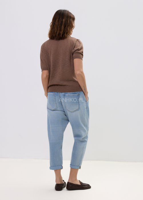 Brązowa bluzka dzianinowa damska z krótkim rękawem i wiązaną apaszką przy dekolcie, o klasycznym kroju, zestawiona z jasnymi jeansami w stylu casual.