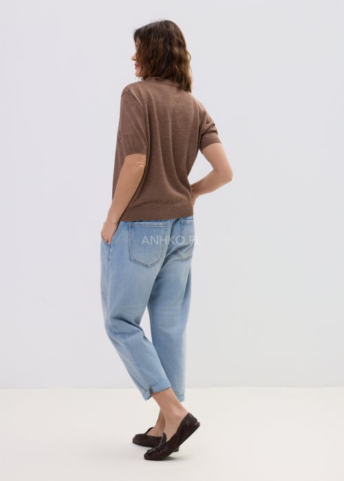 Brązowa bluzka dzianinowa damska z krótkim rękawem i wiązaną apaszką przy dekolcie, o klasycznym kroju, zestawiona z jasnymi jeansami w stylu casual.