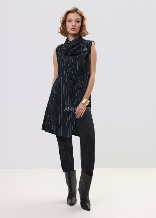 Czarne spodnie damskie z prostą nogawką i elastycznym pasem, o minimalistycznym fasonie, zestawione ze sneakersami w codziennej stylizacji.