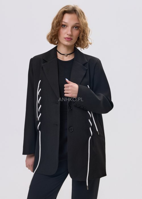 Czarna marynarka damska o prostym kroju z ozdobnymi białymi sznurkami po bokach i z tyłu, zapinana na guziki.