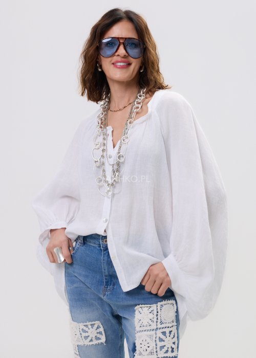 Biała lniana koszula damska oversize z długim rękawem i lekkim, zwiewnym materiałem, stylizowana z jeansami i biżuterią w casualowym looku.