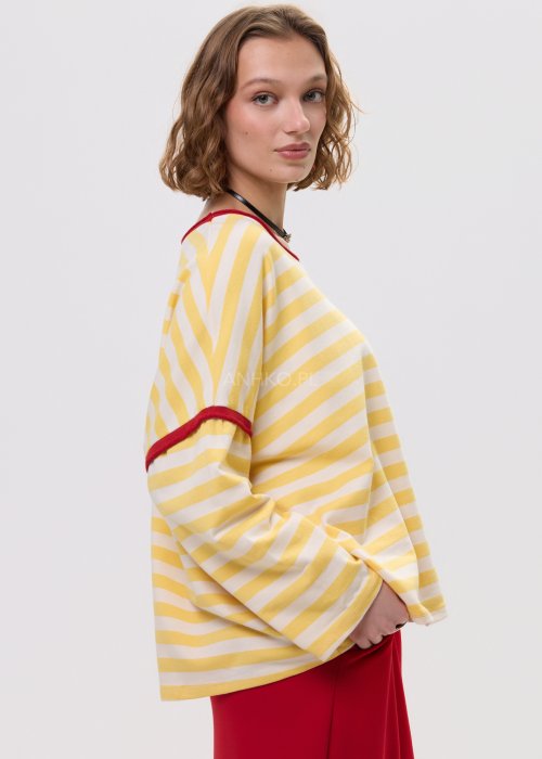 Bluza oversize w żółto-kremowe paski z czerwonym wykończeniem przy dekolcie i rękawach – luźny fason z szerokimi rękawami na sylwetce