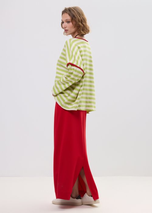 Bluza oversize w limonkowo-kremowe paski z czerwonym wykończeniem przy dekolcie i rękawach – luźny fason z szerokimi rękawami na sylwetce