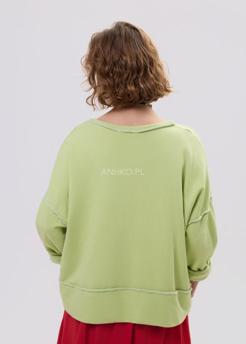 Bluza damska oversize limonkowa z napisem i surowym wykończeniem, luźny fason z obniżoną linią ramion w casualowej stylizacji.