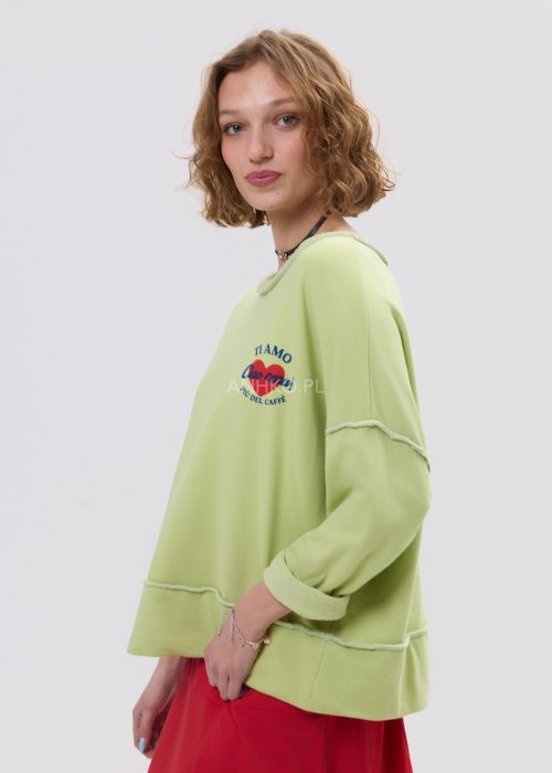Bluza damska oversize limonkowa z napisem i surowym wykończeniem, luźny fason z obniżoną linią ramion w casualowej stylizacji.