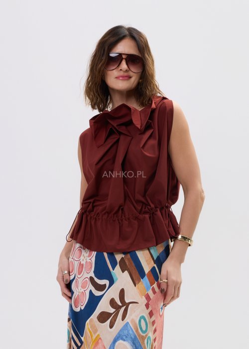 Bluzka bez rękawów w kolorze ceglanym z dekoracyjną falbaną przy dekolcie i marszczeniem w talii – elegancki fason na sylwetce