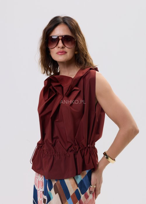 Bluzka bez rękawów w kolorze ceglanym z dekoracyjną falbaną przy dekolcie i marszczeniem w talii – elegancki fason na sylwetce