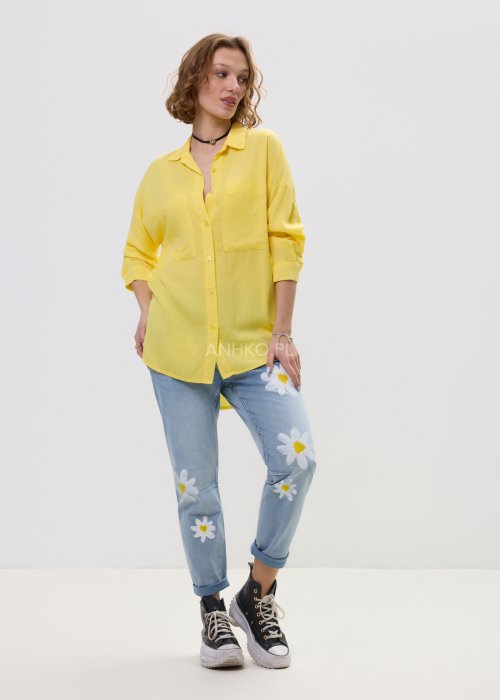Żółta koszula damska o luźnym kroju z długim rękawem, kołnierzykiem i dużymi kieszeniami na piersi.