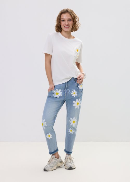 Biała bluzka t-shirt damski z krótkim rękawem i ozdobną kieszonką z ażurową aplikacją w kształcie stokrotki.