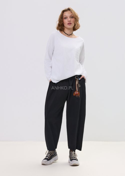 Czarne spodnie damskie o luźnym, nowoczesnym kroju z elastycznym pasem i szeroką nogawką. Model ozdobiony dekoracyjnym brelokiem przy pasie, idealny do codziennych, casualowych stylizacji.