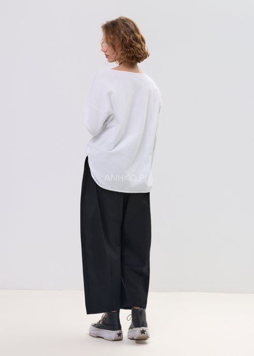 Czarne spodnie damskie o luźnym, nowoczesnym kroju z elastycznym pasem i szeroką nogawką. Model ozdobiony dekoracyjnym brelokiem przy pasie, idealny do codziennych, casualowych stylizacji.