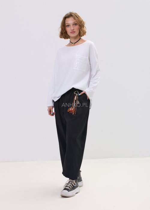 Biała bluzka damska o luźnym, oversize’owym kroju z długim rękawem i okrągłym dekoltem. Model ozdobiony kieszonką z delikatnymi cekinami, który nadaje całości subtelnego, dekoracyjnego charakteru