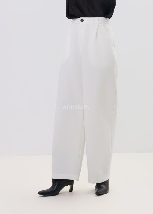 Białe spodnie damskie garniturowe z wysokim stanem, zapinane na guzik, z eleganckimi zakładkami z przodu. Szeroka, lekko zwężana nogawka nadaje im nowoczesny, elegancki charakter.