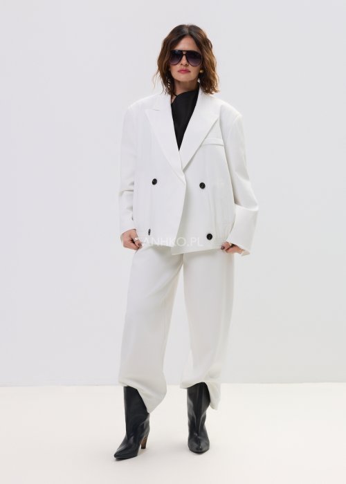 Białe spodnie damskie garniturowe z wysokim stanem, zapinane na guzik, z eleganckimi zakładkami z przodu. Szeroka, lekko zwężana nogawka nadaje im nowoczesny, elegancki charakter.