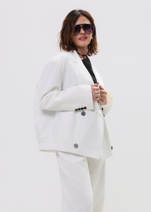 Biała kurtko-marynarka damska o nowoczesnym, lekko oversize’owym kroju, zapinana na guziki, z klasycznymi klapami i kieszenią na piersi.