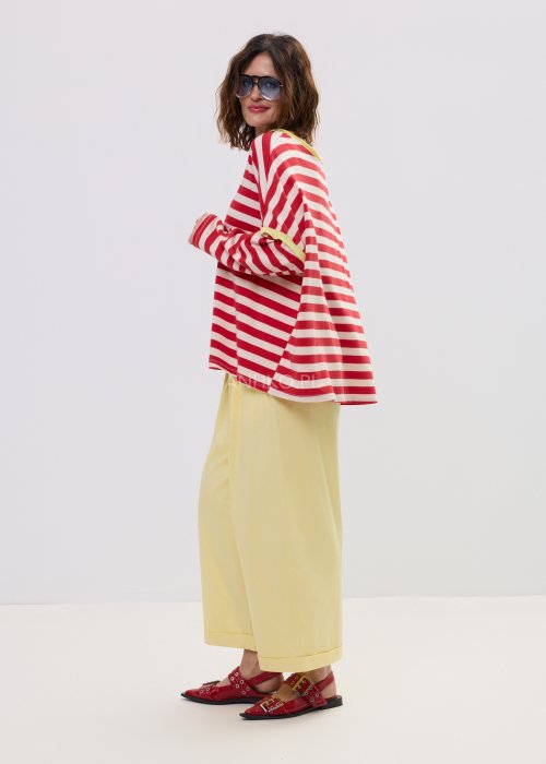 Bluza damska oversize w czerwono-kremowe paski z długim rękawem i kontrastowym, żółtym wykończeniem przy dekolcie oraz rękawach. Luźny, wygodny fason w stylu casual, idealny do codziennych stylizacji.
