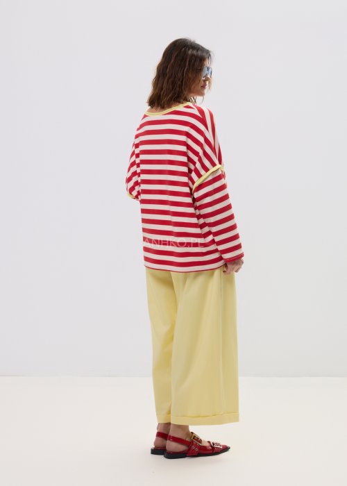 Bluza damska oversize w czerwono-kremowe paski z długim rękawem i kontrastowym, żółtym wykończeniem przy dekolcie oraz rękawach. Luźny, wygodny fason w stylu casual, idealny do codziennych stylizacji.