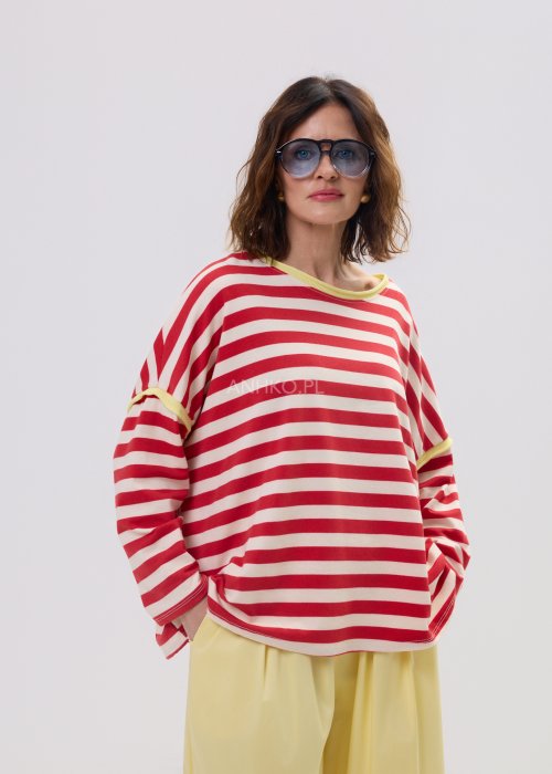 Bluza damska oversize w czerwono-kremowe paski z długim rękawem i kontrastowym, żółtym wykończeniem przy dekolcie oraz rękawach. Luźny, wygodny fason w stylu casual, idealny do codziennych stylizacji.