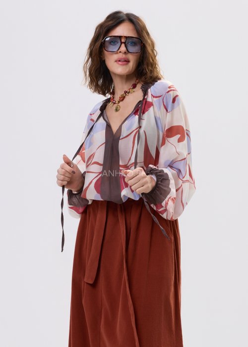 Damski naszyjnik z czerwonych koralików z ozdobnymi złotymi zawieszkami i medalionem.