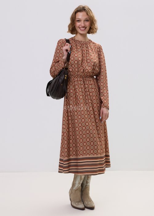 Wzorzysta sukienka midi z wiskozy w retro print w odcieniach brązu, z marszczonym dekoltem i gumką w pasie. Stylizacja z jasnymi kowbojkami i czarną torebką podkreśla modowy charakter modelu.