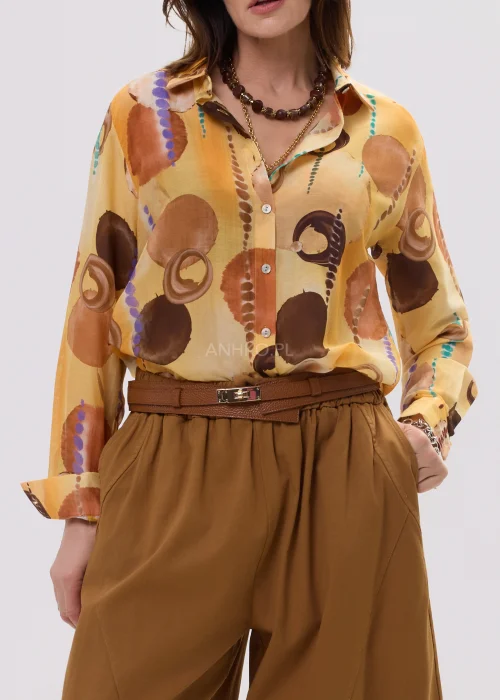 Koszula damska w odcieniu pmorańczowym z abstrakcyjnym printem, o lekkim, półtransparentnym materiale i klasycznym kołnierzyku.