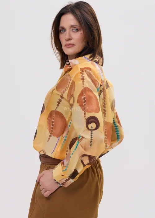 Koszula damska w odcieniu pmorańczowym z abstrakcyjnym printem, o lekkim, półtransparentnym materiale i klasycznym kołnierzyku.