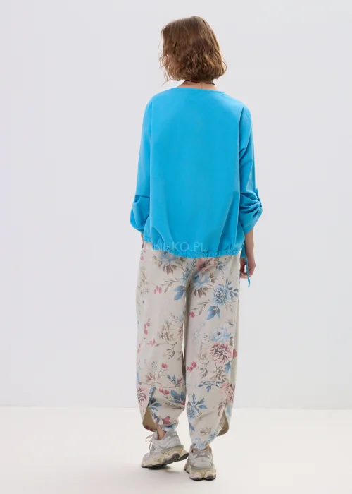 Niebieska bluzka damska o luźnym kroju z długim rękawem, regulowane wiązania i elastyczne wykończenie, casualowy styl.