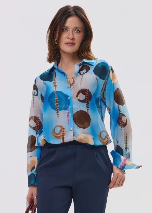 Koszula damska w artystyczny print w odcieniach niebieskiego i brązu, lekka tkanina, klasyczny kołnierz – elegancka stylizacja z granatowymi spodniami.