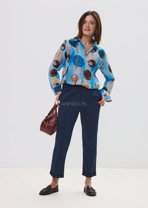 Koszula damska w artystyczny print w odcieniach niebieskiego i brązu, lekka tkanina, klasyczny kołnierz – elegancka stylizacja z granatowymi spodniami.