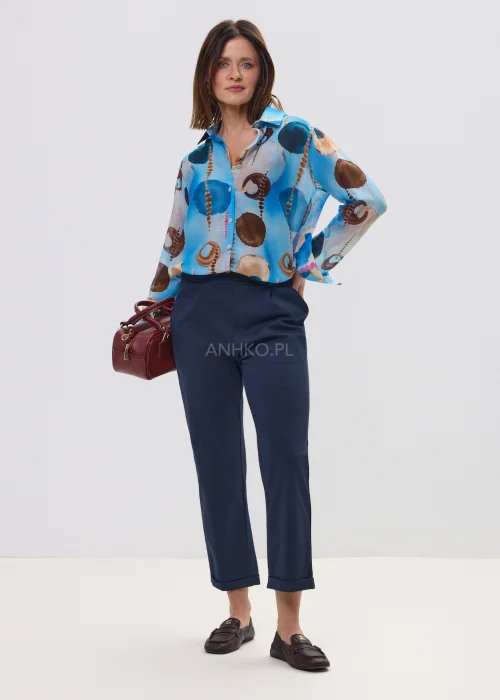 Koszula damska w artystyczny print w odcieniach niebieskiego i brązu, lekka tkanina, klasyczny kołnierz – elegancka stylizacja z granatowymi spodniami.